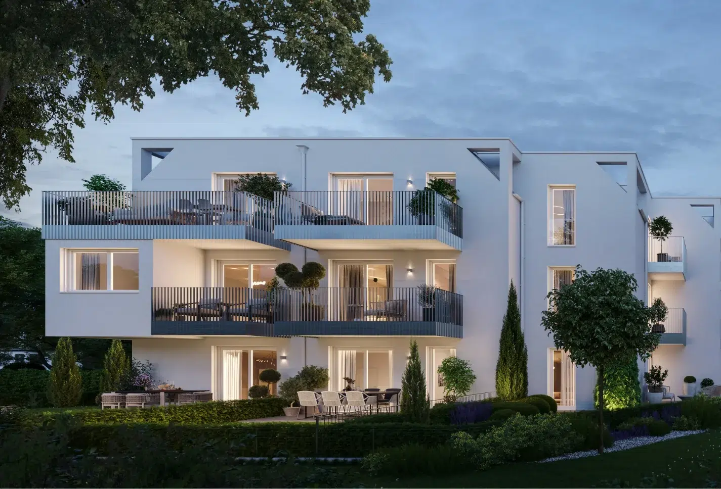 Abendlich beleuchtete Außenansicht des Wohnprojekts AG3 mit großzügigen Balkonen und Garten.