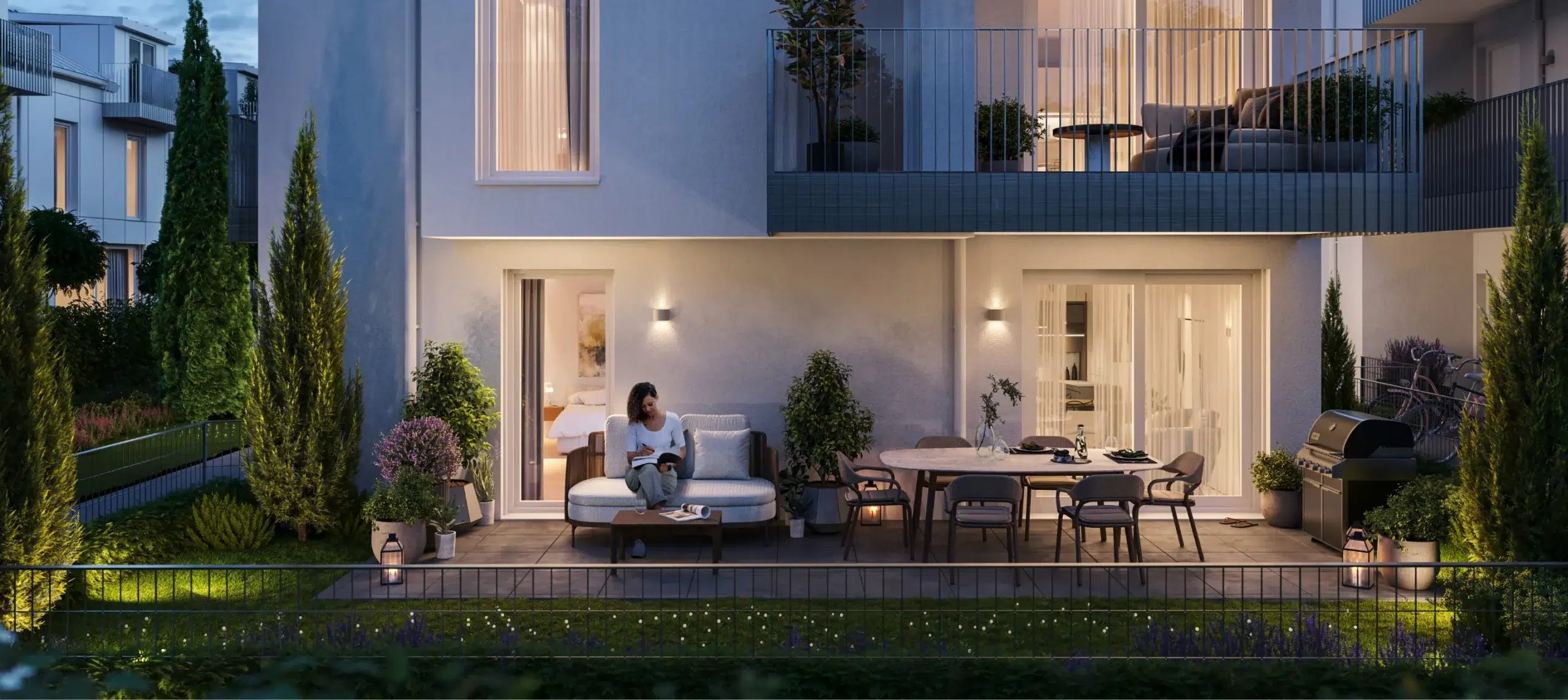 Abendszene einer möblierten Terrasse mit Frau auf einer Gartenbank, stimmungsvolle Beleuchtung, gepflegter Garten und Blick in ein modernes Wohnhaus.