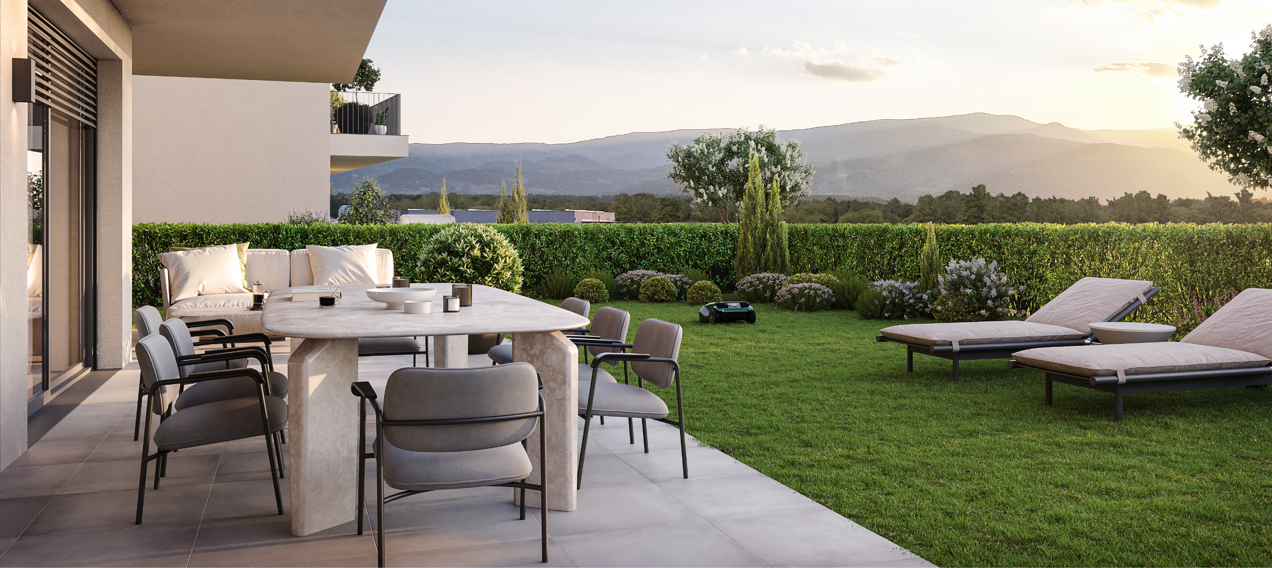 Moderne Terrasse mit Garten, Lounge-Möbeln und Blick auf die umliegende Berglandschaft.