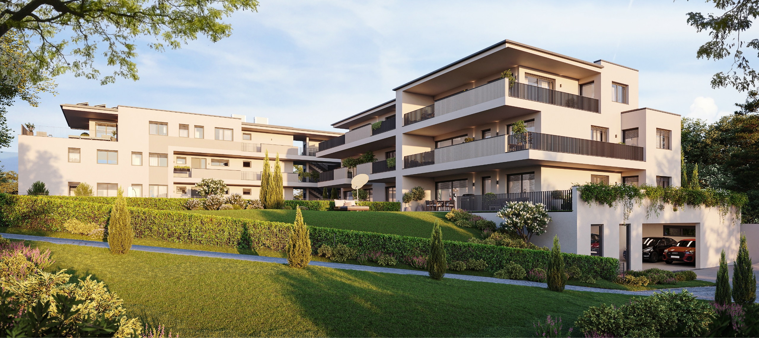 Modernes Wohngebäude mit großen Balkonen, gepflegter Gartenanlage und Tiefgaragenzufahrt.